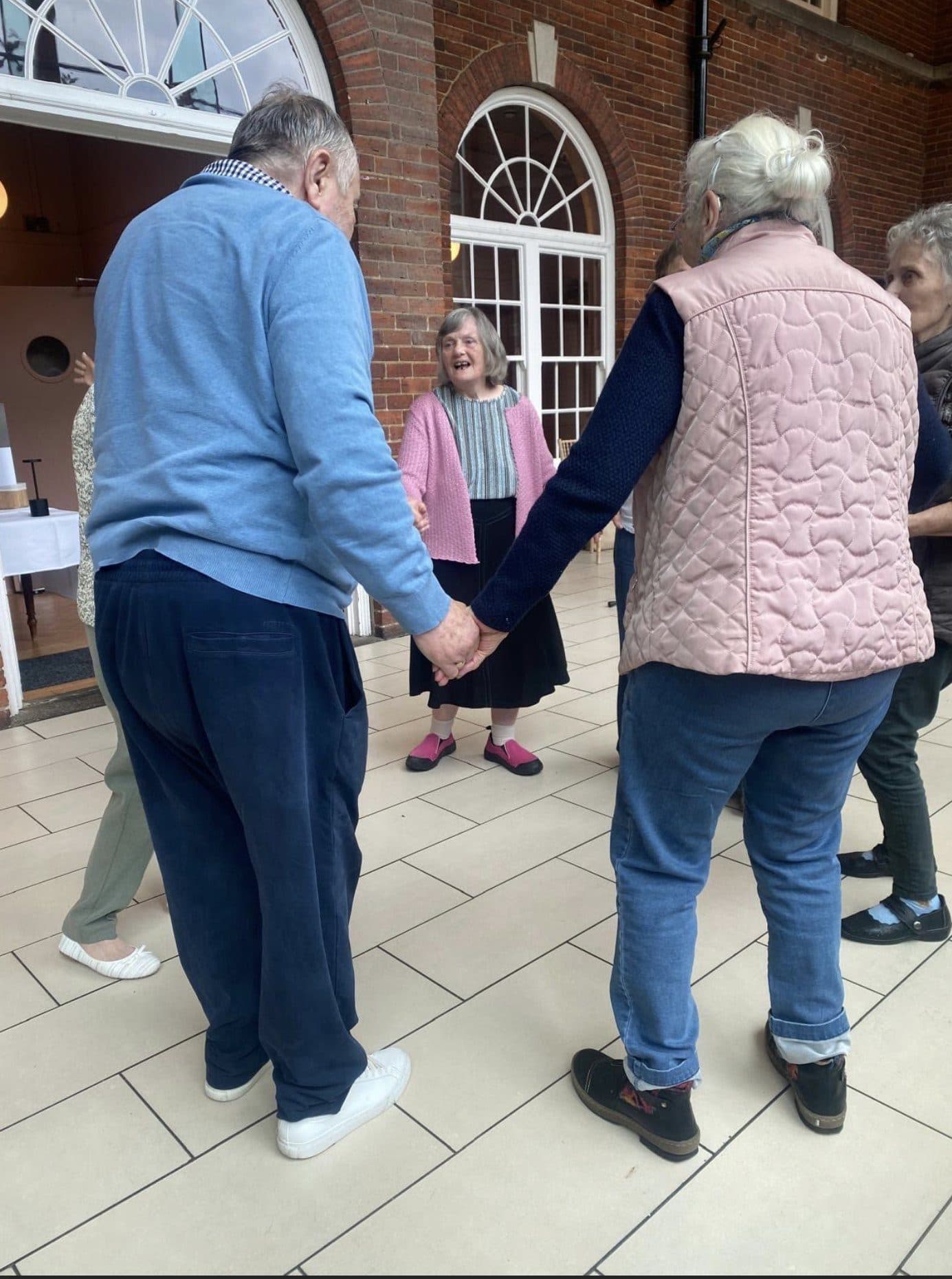 Residents holding hands in a circle during a group activity